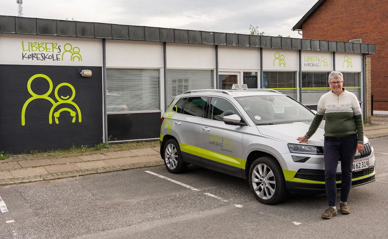 Libber Seindal Krabbe foran Libbers Køreskole med skolevognen